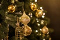 Close up view of beautiful fir branches with shiny golden bauble or ball, xmas ornaments and lights, Christmas holidays Royalty Free Stock Photo