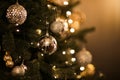 Close up view of beautiful fir branches with shiny golden bauble or ball, xmas ornaments and lights, Christmas holidays Royalty Free Stock Photo