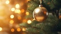 Close up view of beautiful fir branches with shiny golden bauble or ball, xmas ornaments and lights, Christmas holidays background Royalty Free Stock Photo