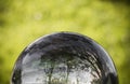 Close up view on beautiful landscape trees in blue sky and green meadow through lens ball sphere, france Royalty Free Stock Photo