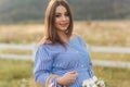 Close up view of Beautiful pregnant woman in blue dress walking hear the farm. Smile and happines