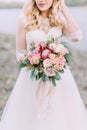 Close-up view of the beautiful wedding bouquet of red flowers in the hands of the bride. Royalty Free Stock Photo