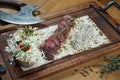 Close up view on Beef fillet or sliced steak medium rare with a side dish of baked potatoes and mushroom salad on a wooden board. Royalty Free Stock Photo