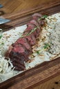 Close up view on Beef fillet or sliced steak medium rare with a side dish of baked potatoes and mushroom salad on a wooden board. Royalty Free Stock Photo