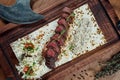 Close up view on Beef fillet or sliced steak medium rare with a side dish of baked potatoes and mushroom salad on a wooden board. Royalty Free Stock Photo