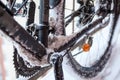 Close up view of bicycle sprocket, chain and treadle covered with ice and snow at winter time, bicycling at winter