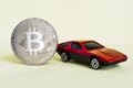 Close-up view of bitcoin and red car. Royalty Free Stock Photo