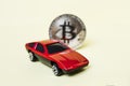 Close-up view of bitcoin and red car. Royalty Free Stock Photo