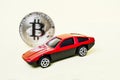 Close-up view of bitcoin and red car. Royalty Free Stock Photo