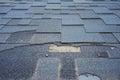 Close up view of bitumen shingles roof damage that needs repair.