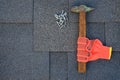 Close up view on bitumen shingles on a roof with hammer,nails and stationery knife background