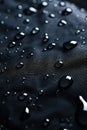 Close-up view of black fabric with water droplets scattered uniformly, creating tranquil atmosphere. Textured surface