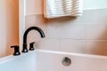 Close up view of black gooseneck faucet on the rim of a bathtub inside bathroom Royalty Free Stock Photo