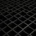 A close-up view of a black metal grid structure featuring a pattern of square openings. Royalty Free Stock Photo