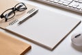 Close-up view, Blank space on a sketchbook with book, pencil, glasses, keyboard and mouse is elements. Royalty Free Stock Photo