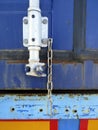 A close up view of a Blue container truck door lock. Rusty truck door latch with old chain. Grunge secured and Locked truck doors Royalty Free Stock Photo