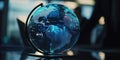 A close-up view of a blue globe resting on a transparent glass table, ideal for use in educational or corporate settings Royalty Free Stock Photo