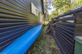 Close up view of blue kayak parked near dark house wall.