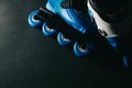 Close up view of blue roller skates inline skate or rollerblade on dark tinted grunge backgroung Royalty Free Stock Photo