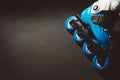 Close up view of blue roller skates inline skate or rollerblade on dark tinted grunge backgroung Royalty Free Stock Photo