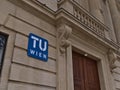 Close-up view of the blue and white logo of TU Wien on the main building on the campus in Vienna, Austria.