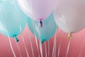 Close up view of blue, white and purple balloons on pink background. Royalty Free Stock Photo