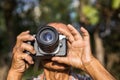 Close-up view of both hands of an elderly Thai man holding a film camera Royalty Free Stock Photo