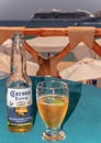 Close up view of bottle of Corona beer at outdoors beach bar table.