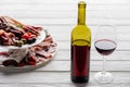 Close up view of bottle and glass of red wine and various meat appetisers with olives Royalty Free Stock Photo