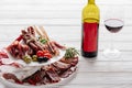 Close up view of bottle and glass of red wine and various meat appetisers with olives Royalty Free Stock Photo