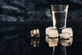 Close-up view of bottle and glasses of vodka standing isolated on black.