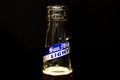 Close up view of the bottle mouth of San Miguel Light beer with silver and blue label in a black marble background