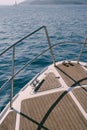 Close up view of the bow of a white yacht sailing on the blue sea