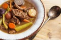 Close up view of a bowl of beef stew with carrots, celery and potatoes. Shown with antique silver spoon. Royalty Free Stock Photo