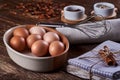 Close-up view of a bowl of hen`s eggs, dish-cloth.and whisk. Raisins on old wooden board table Royalty Free Stock Photo