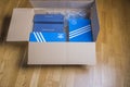 Close up view of box received in mail for home delivery with adidas shoes and sneakers.