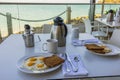 Close-up view of breakfast table in open-air hotel restaurant on Atlantic ocean coast. Royalty Free Stock Photo