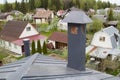 close-up view of a brick stone pipe covered with metal sheets and a black smoke box on a gray fold roof Royalty Free Stock Photo