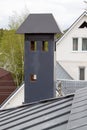 close-up view of a brick stone pipe covered with metal sheets and a black smoke box on a gray fold roof Royalty Free Stock Photo