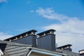 Close-up view of brick stone pipe covered with metal sheets and a black smoke box on roof. Ventilation pipe on roof of modern Royalty Free Stock Photo