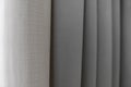 Close-up view of bright curtain in thin and thick vertical folds made of dense fabric.Textured abstract backgrounds and