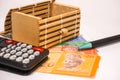 Brown gift box on malaysia notes with calculator and pen Royalty Free Stock Photo