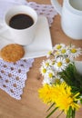 Daisies and dandelions, a cup of coffee and a cookie on a wooden table Royalty Free Stock Photo