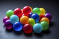 Close up view of bunch vibrant multi coloured glossy balls on a dark surface.