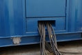 Close up view on bundle of black cables come out from blue power pack or portable generator. Royalty Free Stock Photo