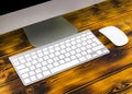 Close up view of a business workplace with computer, wireless computer keyboard, keys and mouse on old dark burned wooden table Royalty Free Stock Photo