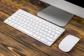 Close up view of a business workplace with computer, wireless keyboard keys and mouse on old dark burned wooden table background. Royalty Free Stock Photo