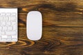 Close up view of a business workplace with wireless computer keyboard, keys and mouse on old dark burned wooden table background. Royalty Free Stock Photo