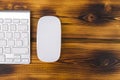 Close up view of a business workplace with wireless computer keyboard, keys and mouse on old dark burned wooden table background. Royalty Free Stock Photo