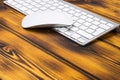 Close up view of a business workplace with wireless computer keyboard, keys and mouse on old dark burned wooden table background. Royalty Free Stock Photo